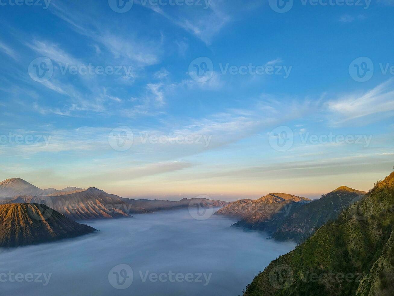 Sunrise view from Penanjakan 2 or Seruni point below can be seen the fog still covers the sea of sand and on the right side of the batok mountain. Beautiful Nature background and wallpaper. photo