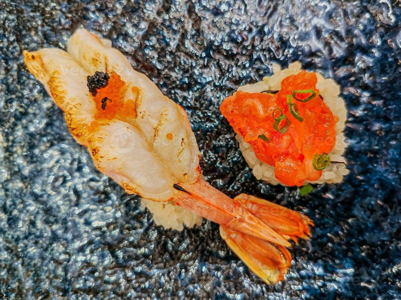 Grilled Shrimp Sushi and Salmon Roe Sushi In a plate. Together, the two sushi contrast in texture and flavor the tender warmth of shrimp juxtaposed with the cool, popping sensation of roe. photo