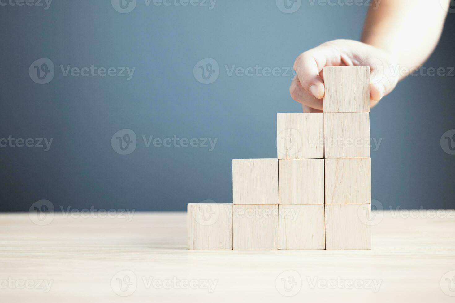 hand of a businessman stacking wood empty ten blocks with copy space for text or symbols, development concept for growth success process. photo