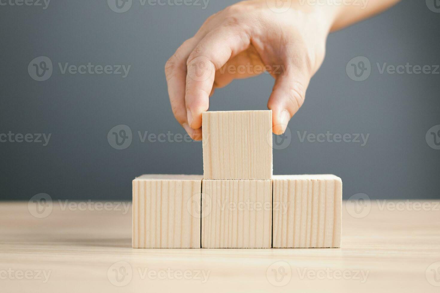 hand of a businessman stacking wood empty four blocks with copy space for text or symbols, development concept for growth success process. photo