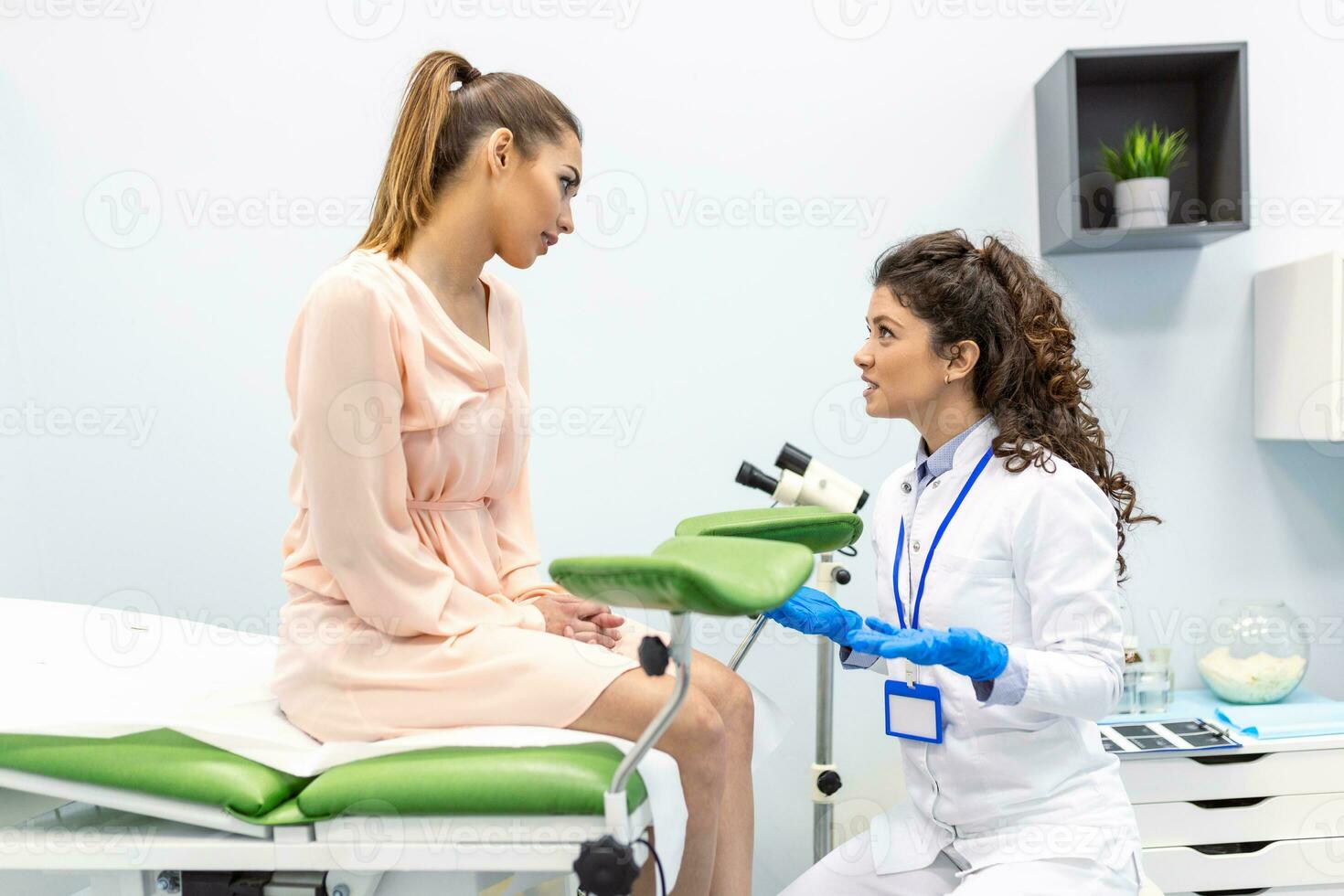 Gynecologist preparing for an examination procedure for a pregnant woman sitting on a gynecological chair in the office photo