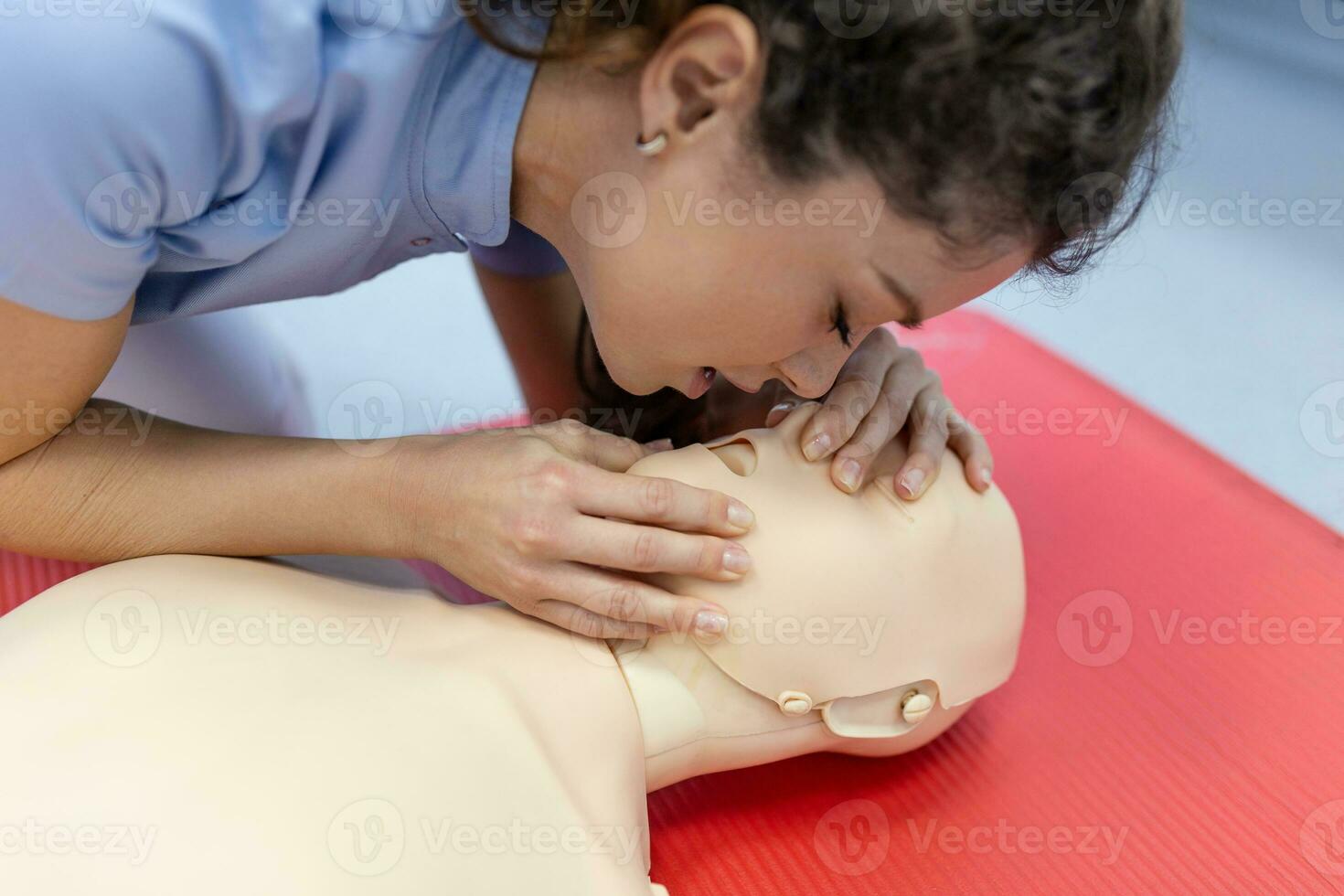 Demonstrating CPR Cardiopulmonary resuscitation  training medical procedure on CPR doll in the class. students are learning how to rescue the patient.First aid for safe life concept. photo