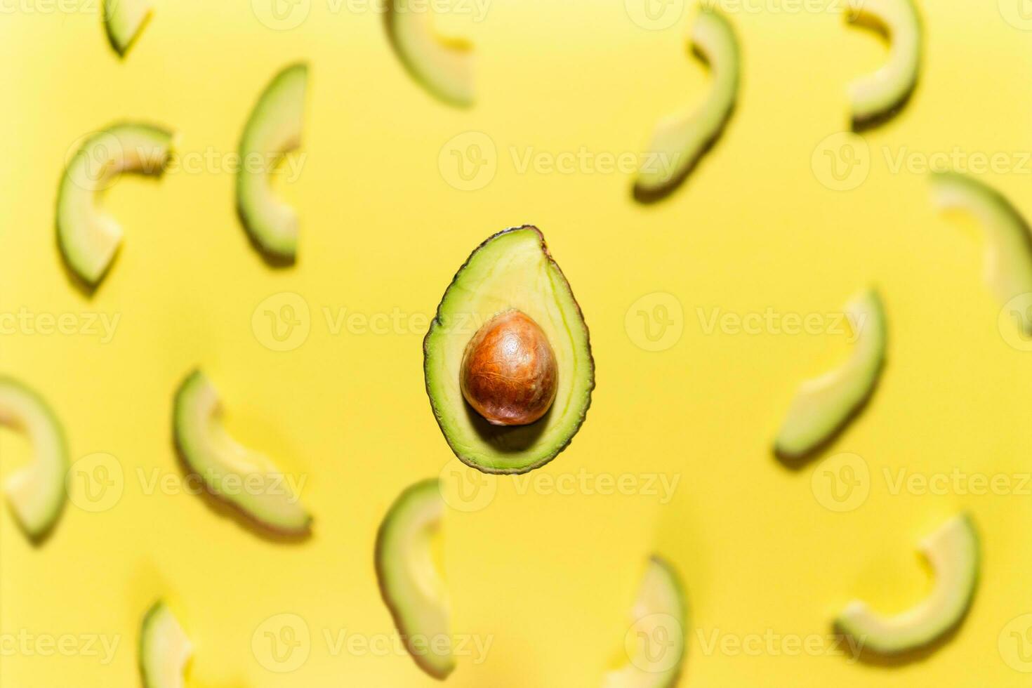 Fresh ripe avocado levitating on yellow background, close up photo