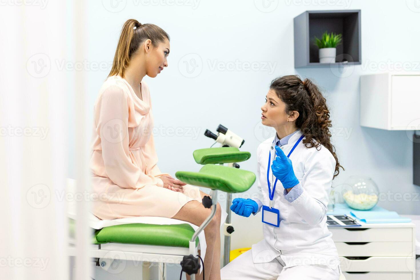 A gynecologist is examined by a patient who is sitting in a gynecological chair. Examination by a gynecologist. Female health concept. photo