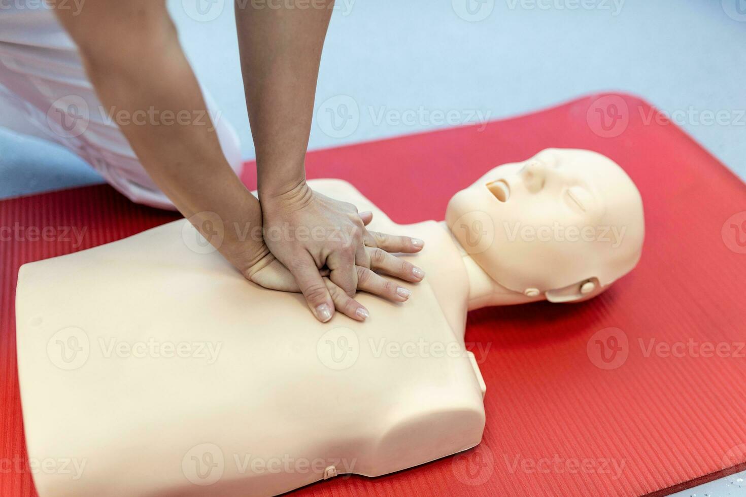 CPR training medical procedure - Demonstrating chest compressions on CPR doll in the class. First Aid Training - Cardiopulmonary resuscitation. First aid course on cpr dummy. photo