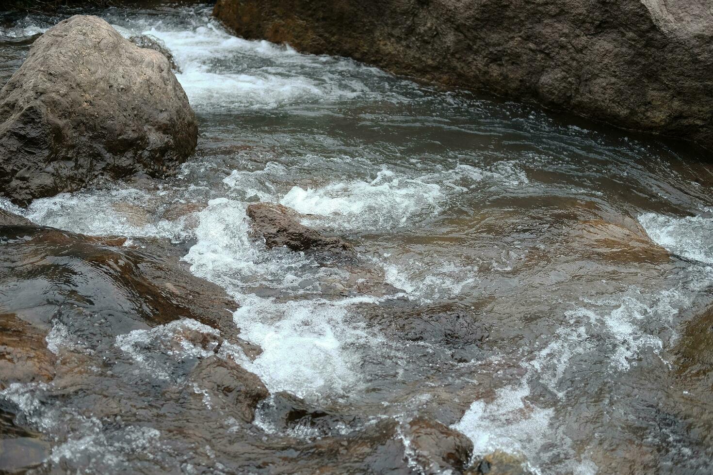 Freshness landscape for  water fall and Stream flowing through rocks in tropical rain forest and greenery wild jungle. photo