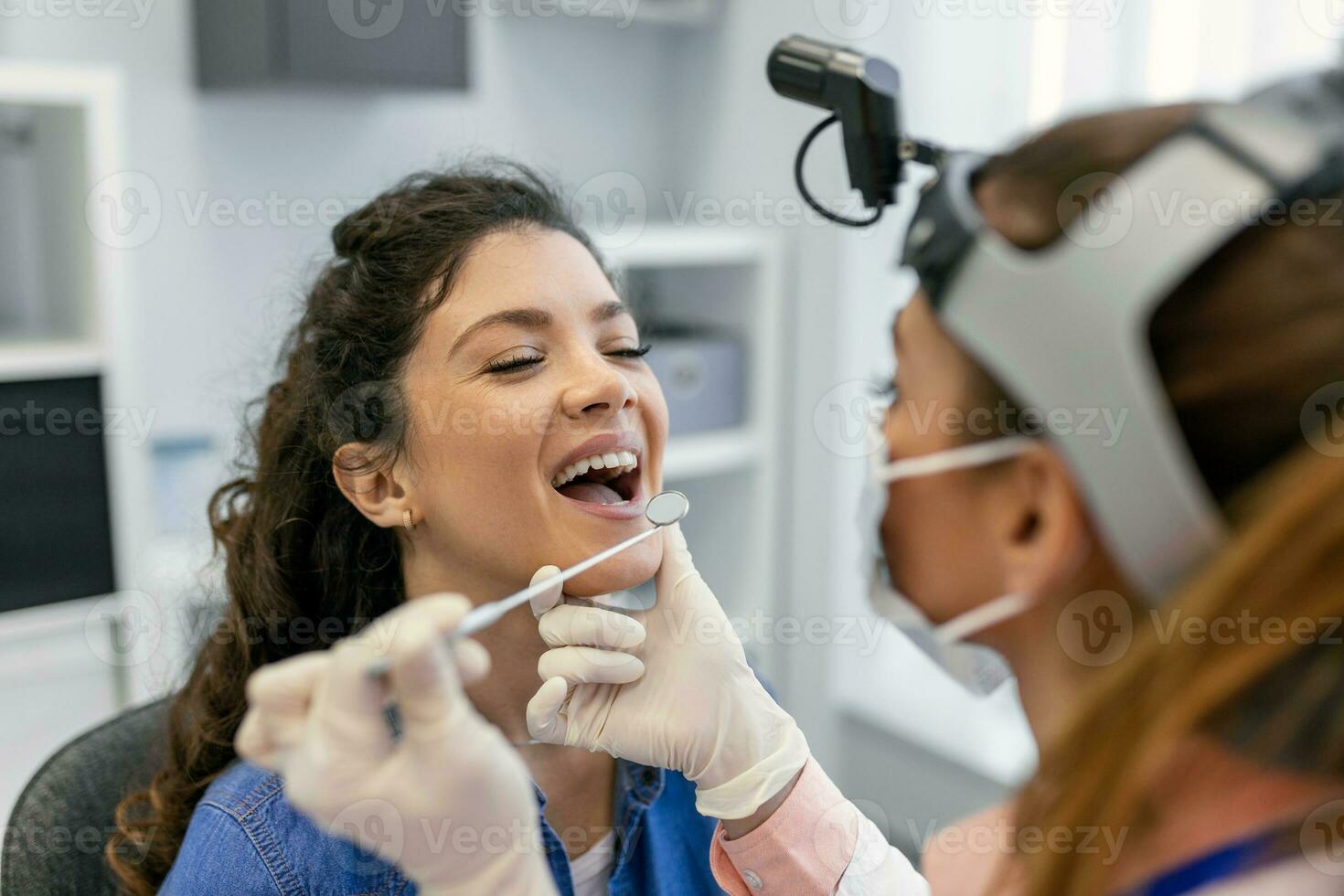 hembra paciente apertura su boca para el médico a Mira en su garganta. hembra médico examinando dolorido garganta de paciente en clínica. otorrinolaringólogo examina dolorido garganta de paciente. foto