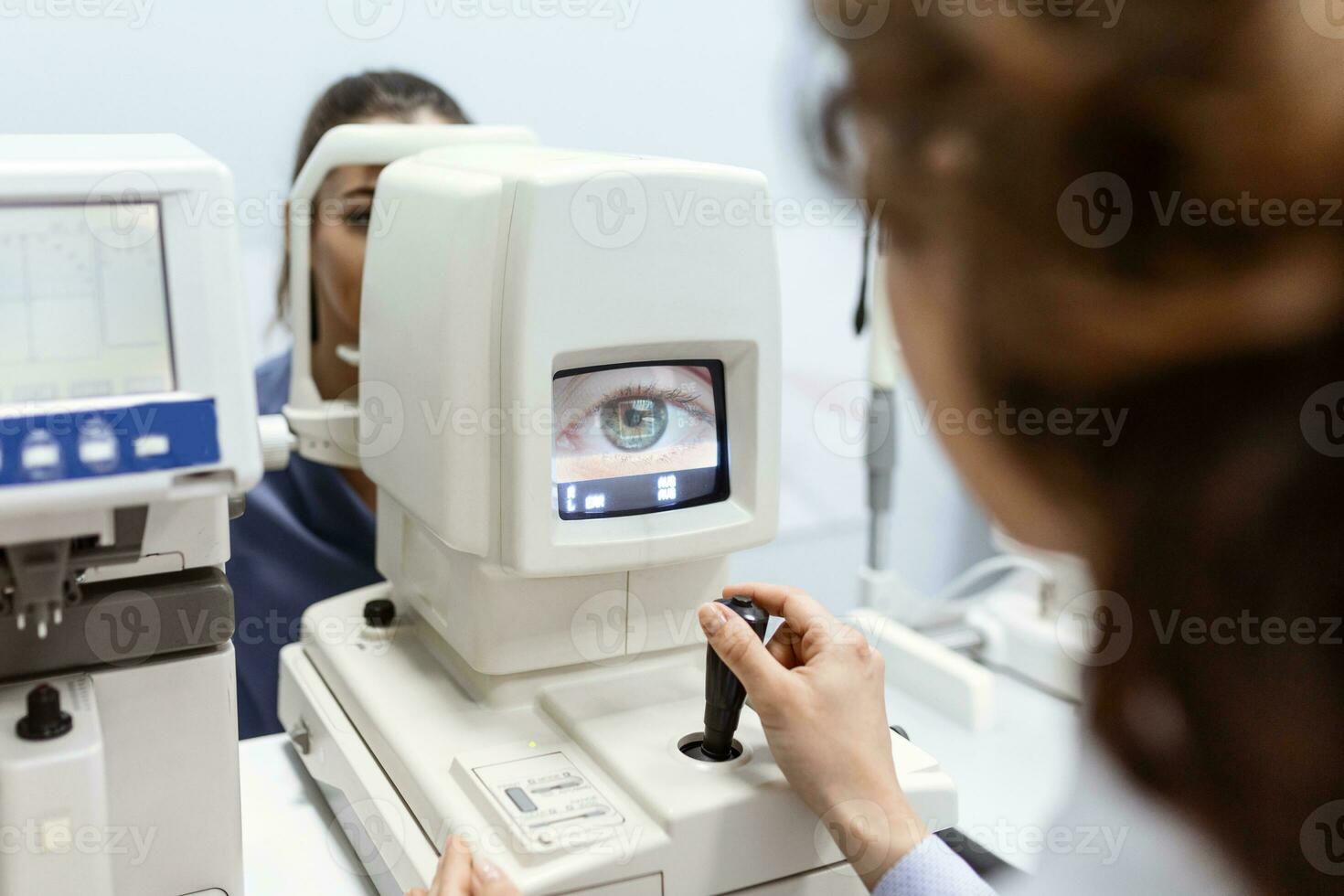Doctor testing for eyes with special optical apparatus in modern clinic. Ophthalmologist examining eyes of a patient using digital microscope during a medical examination in the ophthalmologic office photo