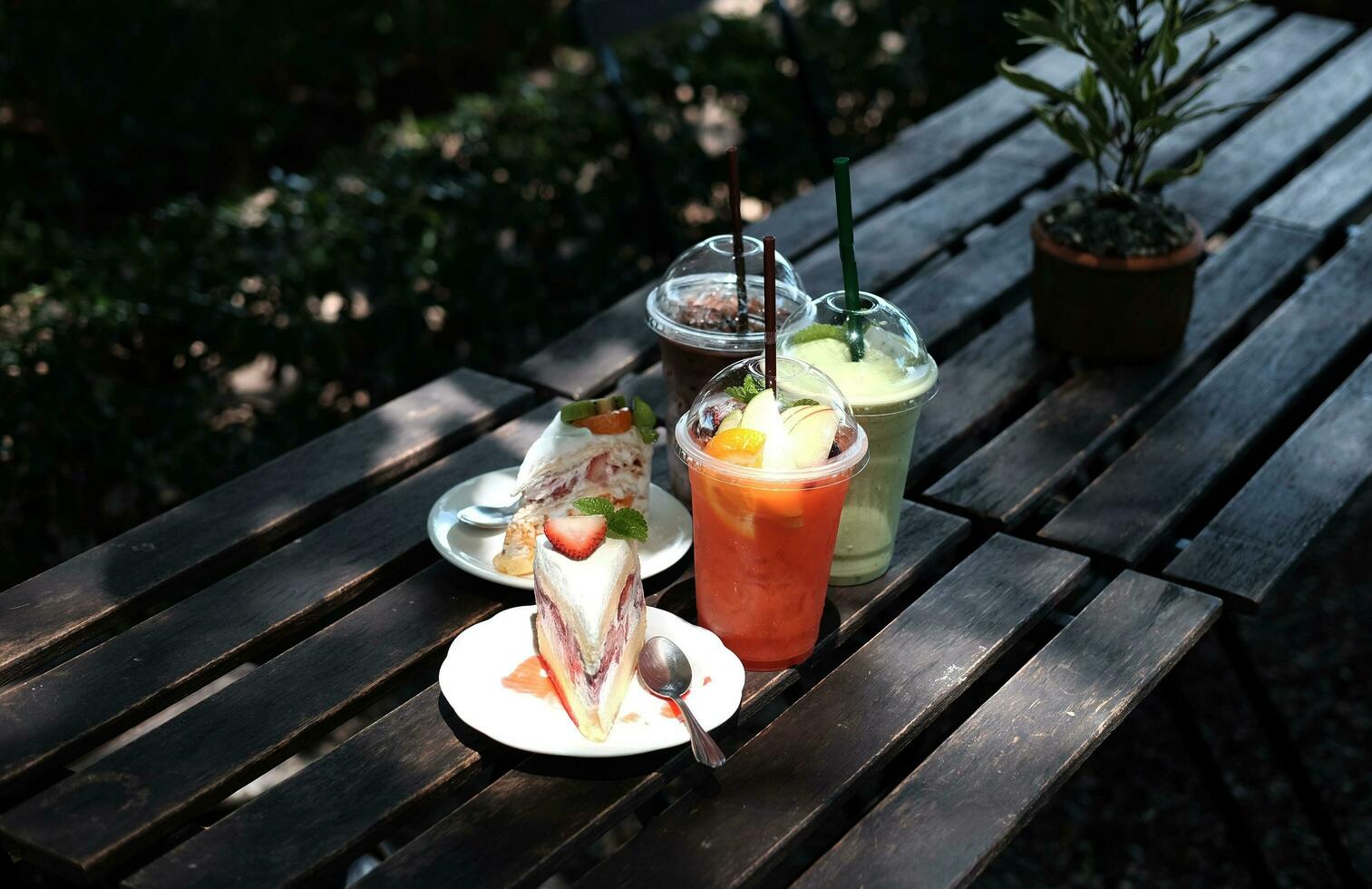 Homemade Bakery for strawberry and kiwi cheese cake in white plate. Fresh Relaxation with dessert and fruit smoothies, Iced coffee, iced green tea in cafe photo