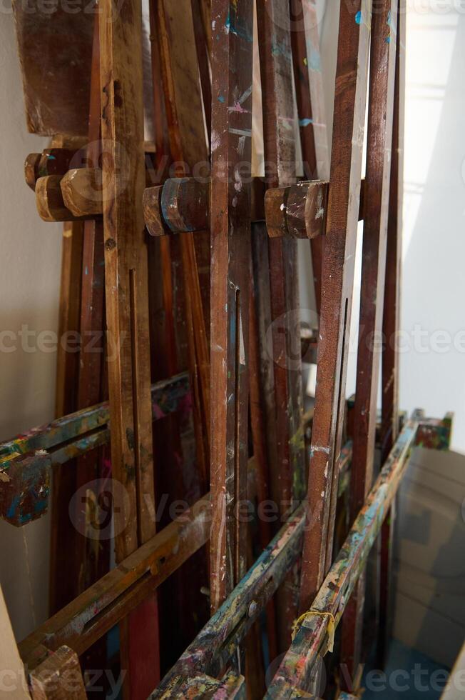 Cropped image of wooden easels smeared with oil paints in a art workshop. Painting tools. Fine art. Creative hobby photo