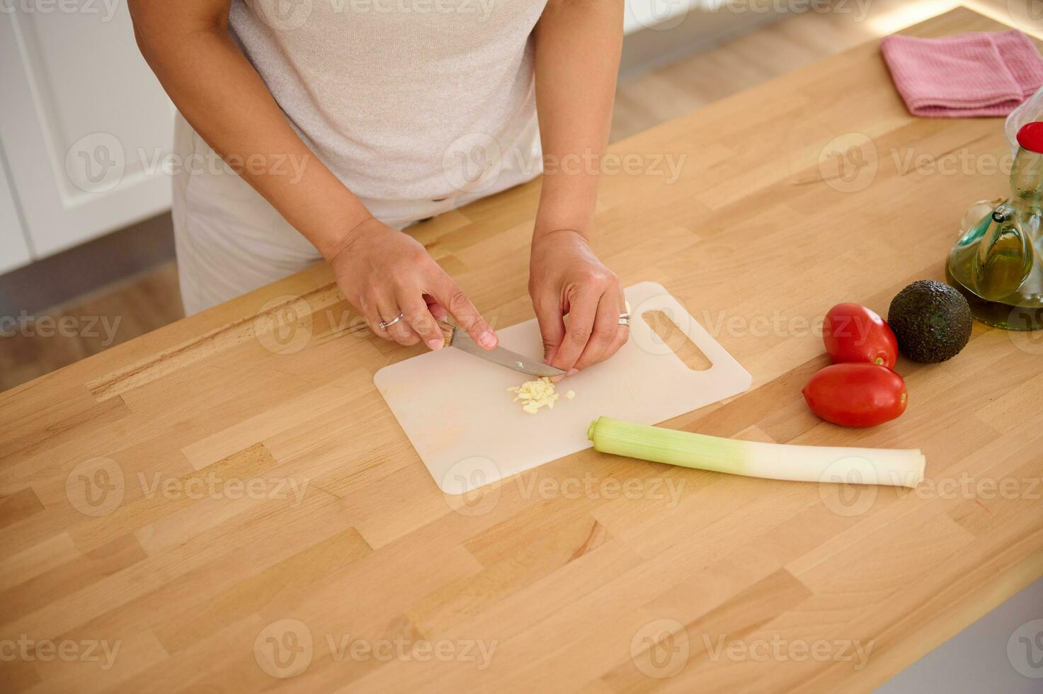 detalles en del chef manos el cortar Puerro y ajo en corte tablero en el minimalista hogar cocina. ver desde encima foto