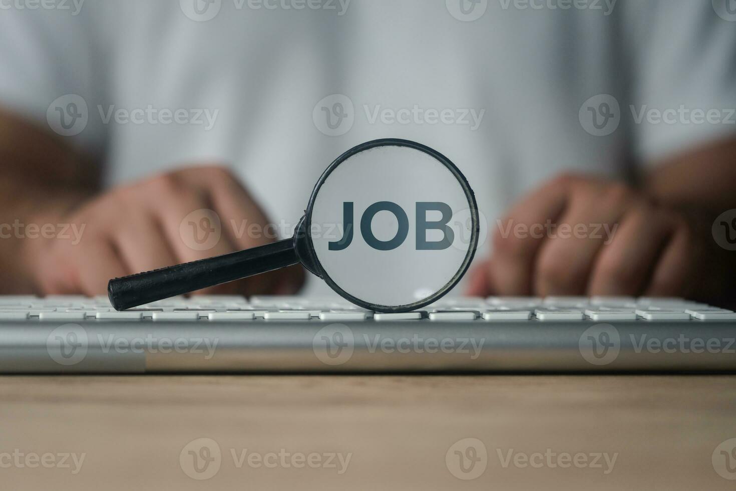 Magnifying glass with job text inside. Searching for a job. photo