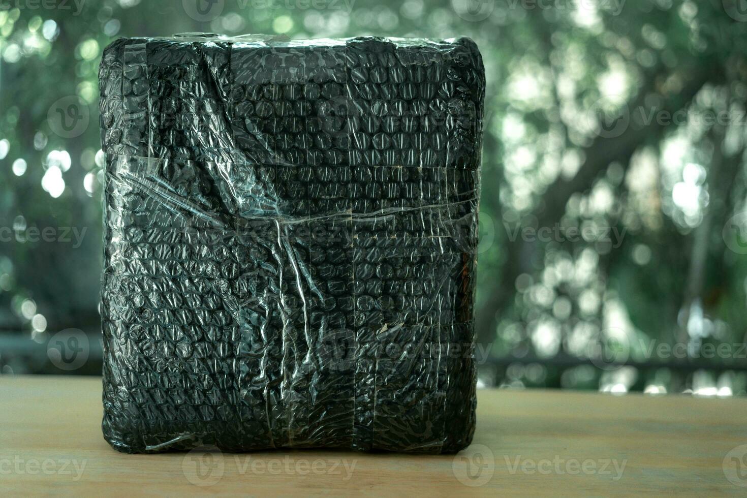 Black bubble wrapped with adhesive tape for packing fragile items. photo
