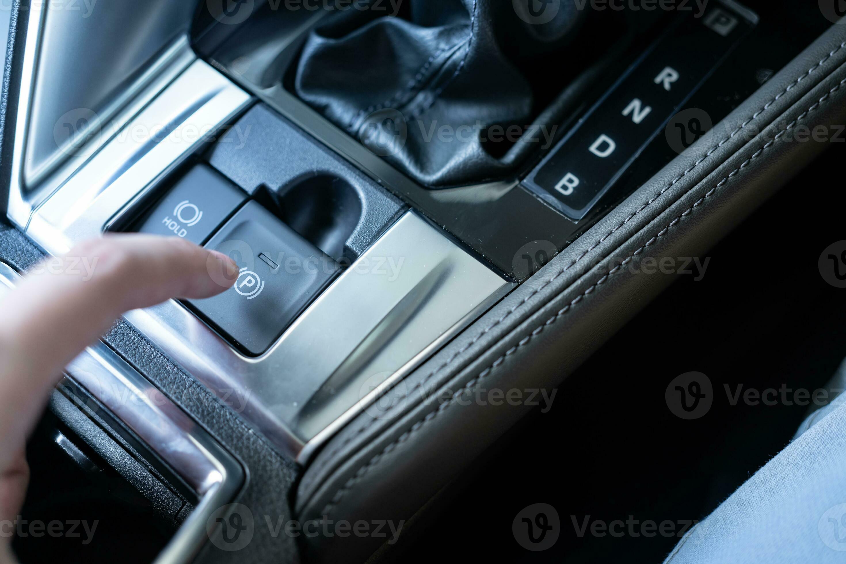 Finger pressing the electronic parking brake button car. Finger push or