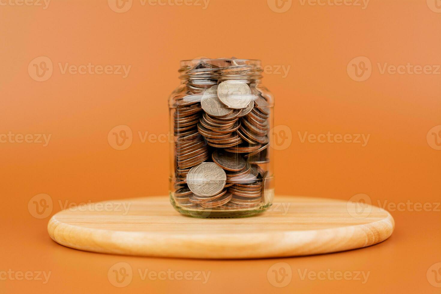 Saving coins in a glass jar money saving concept Finance and banking, mutual funds, cash, cash flow, income, wages, investments, financial growth and investment. photo