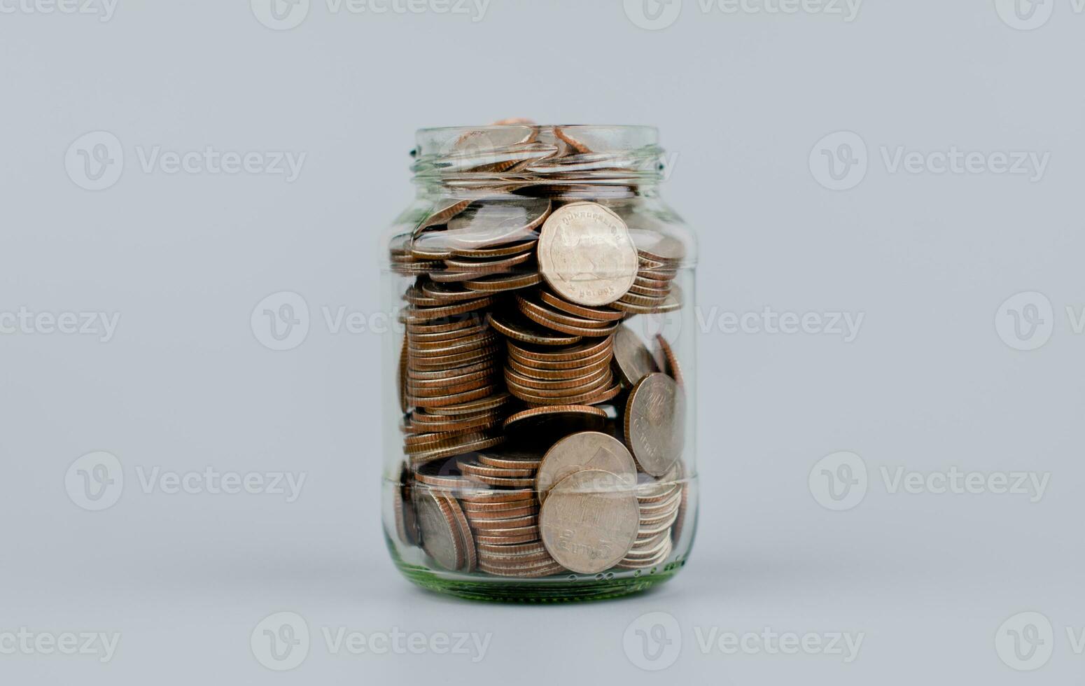 Saving coins in a glass jar money saving concept Finance and banking, mutual funds, cash, cash flow, income, wages, investments, financial growth and investment. photo