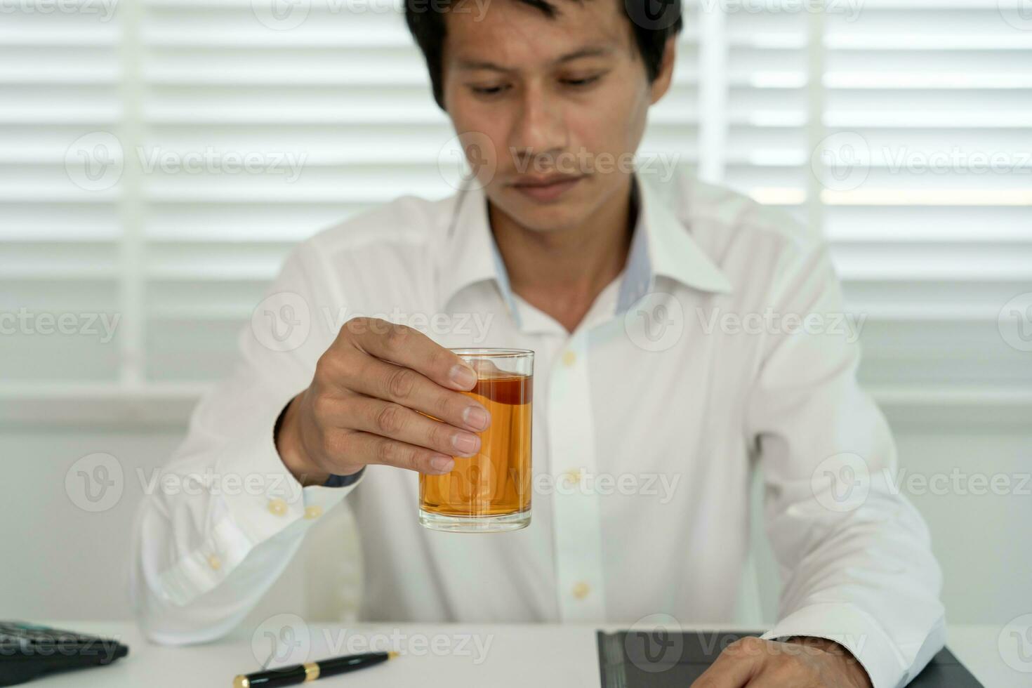 Depressed young business man addicted feeling bad drinking whiskey alone at home, stressed frustrated lonely drinking alcohol suffers from problematic liquor, alcoholism, life and family problems photo