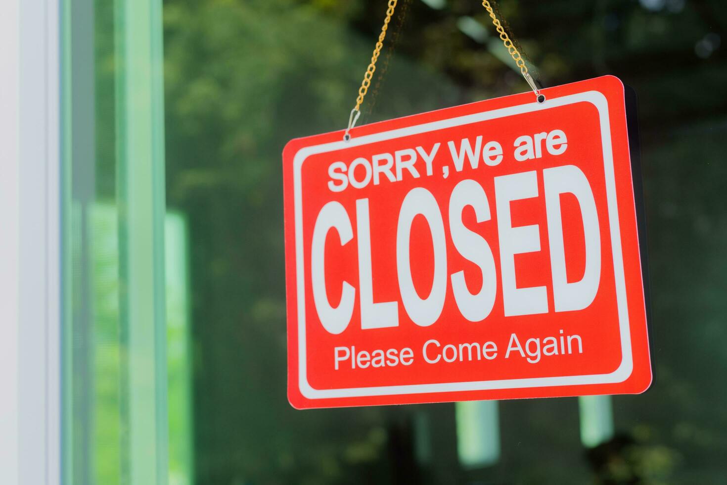 The shop owner hangs a sign to close the business in front of the door. photo