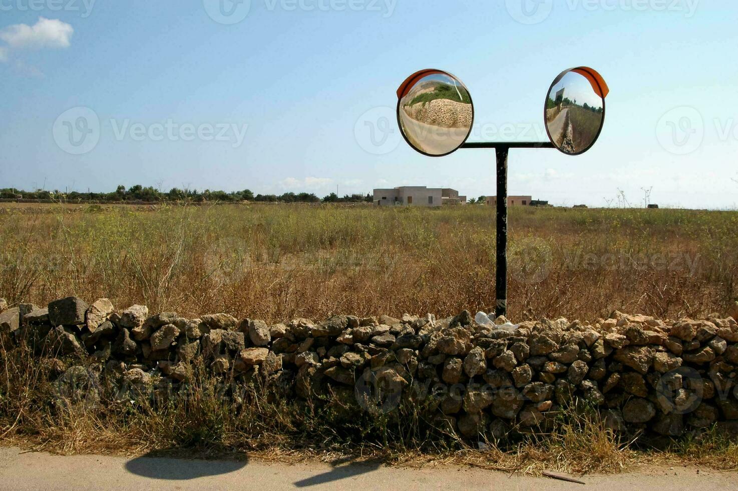 a rock fence with two mirrors on it photo