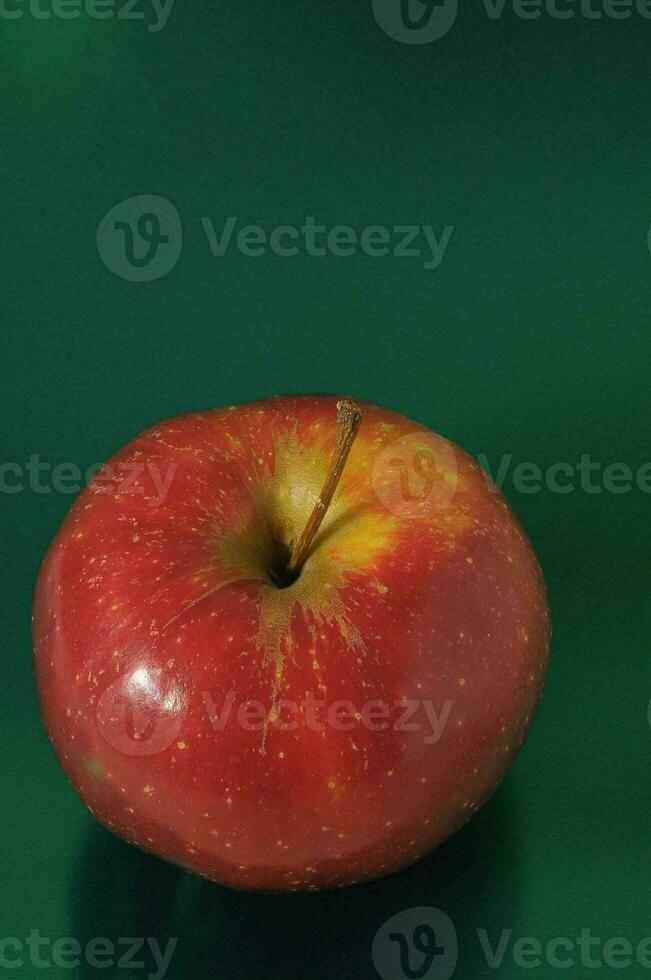 un rojo manzana en un verde superficie foto