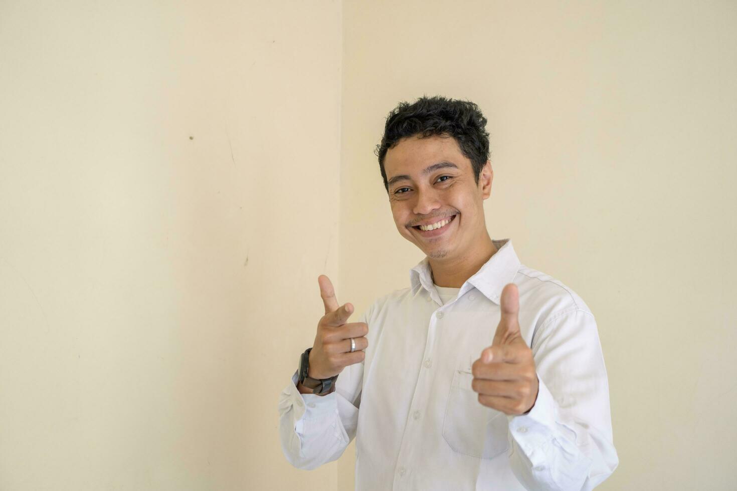 Young Indonesian curly man wear white clothes with cheer pose. photo