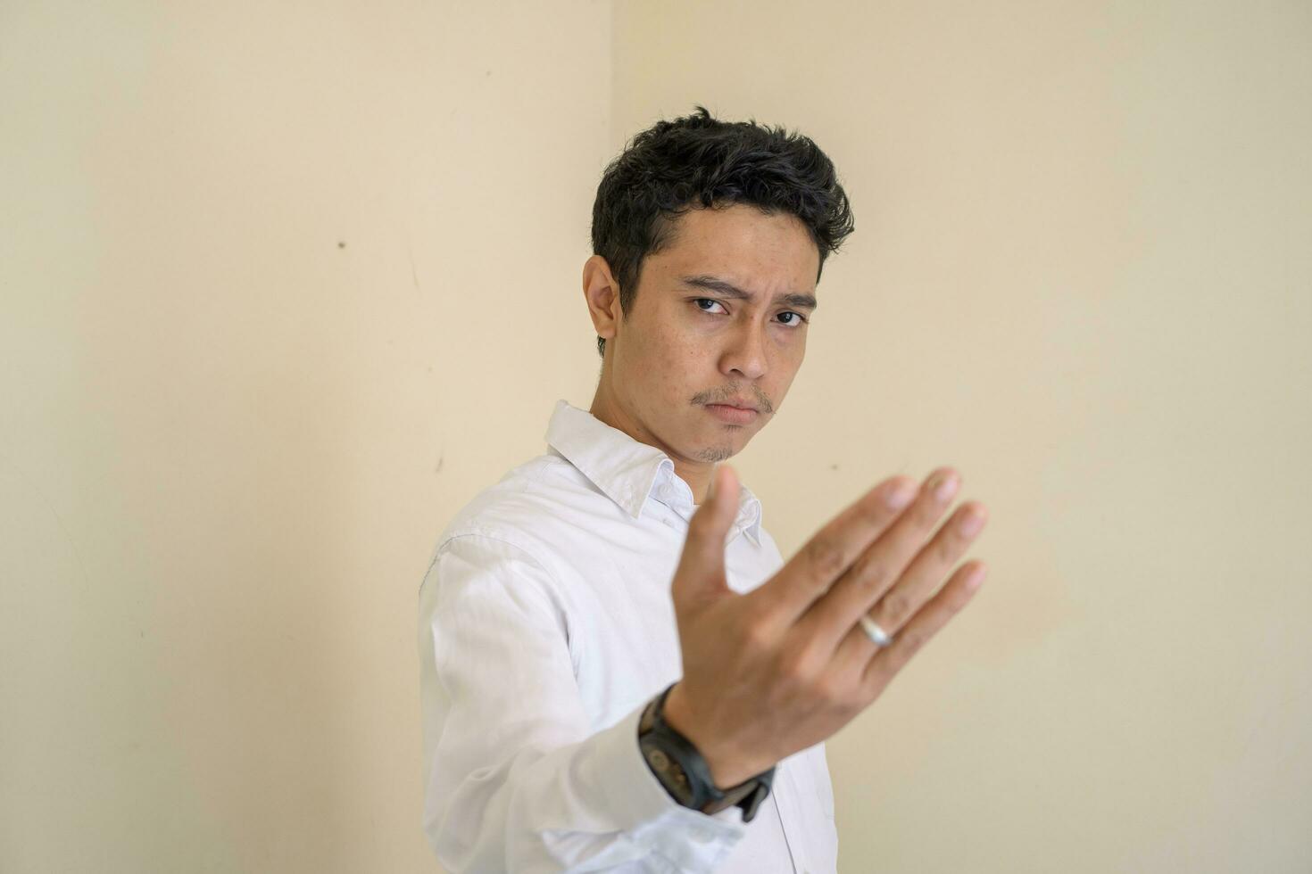 Young Indonesian curly man wear white clothes with fight pose. photo