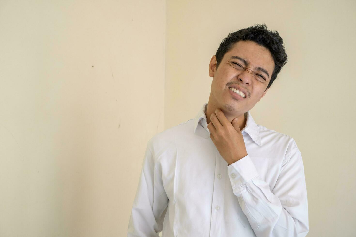 Young Indonesian curly man wear white clothes feel thirsty. photo