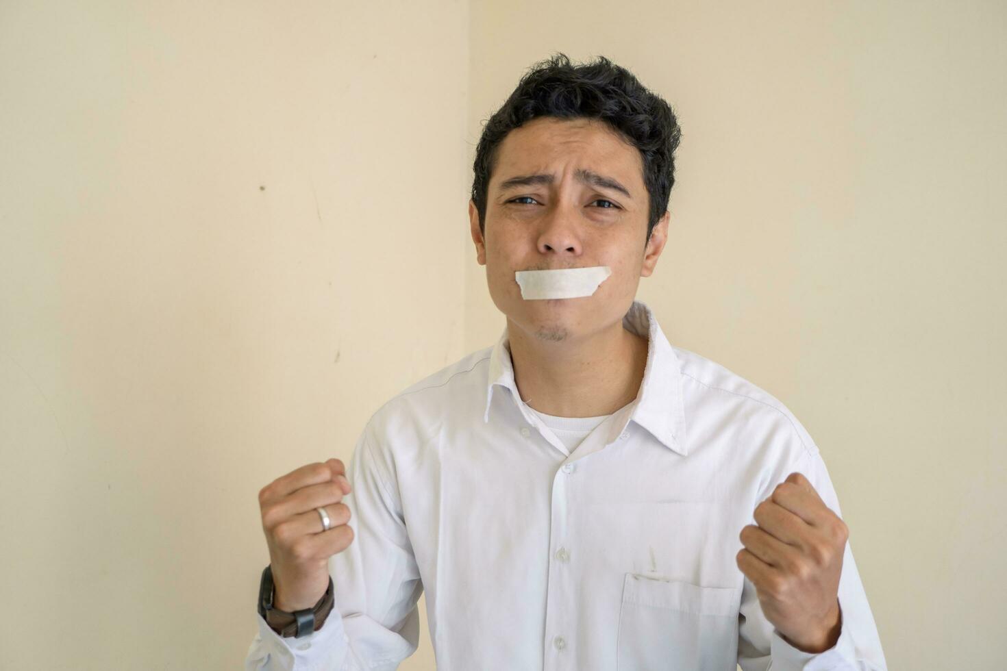 Young Indonesian curly man wear white clothes with isolated mouth pose. photo