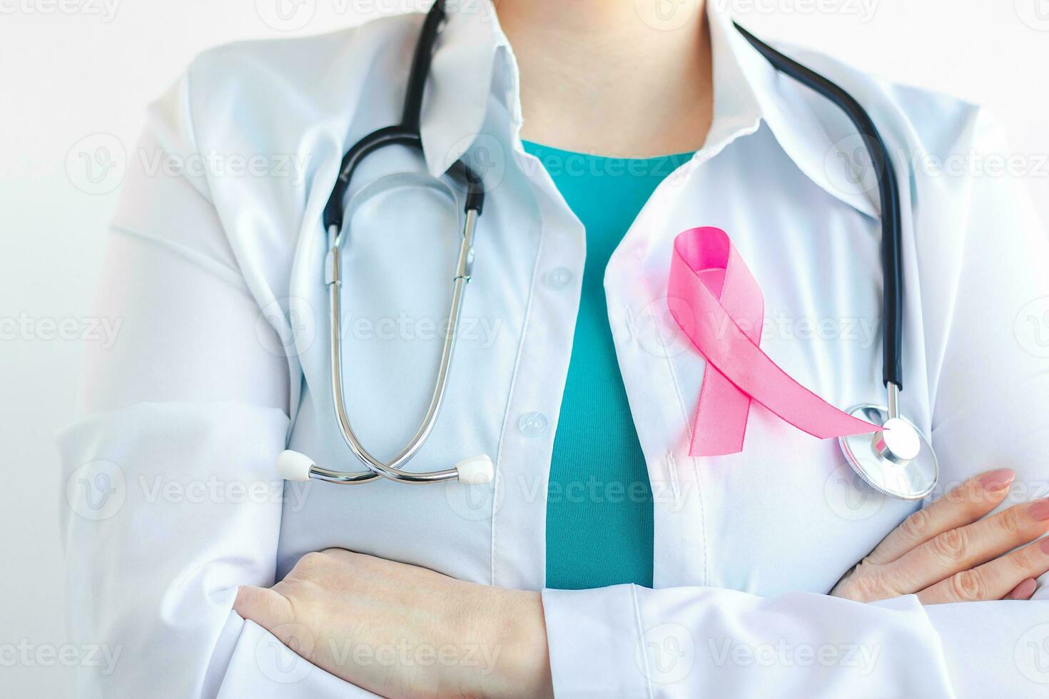 Woman doctor in medical white uniform with pink ribbon. Breast Cancer Awareness Month. Women's health care concept. Symbol of hope and support. photo