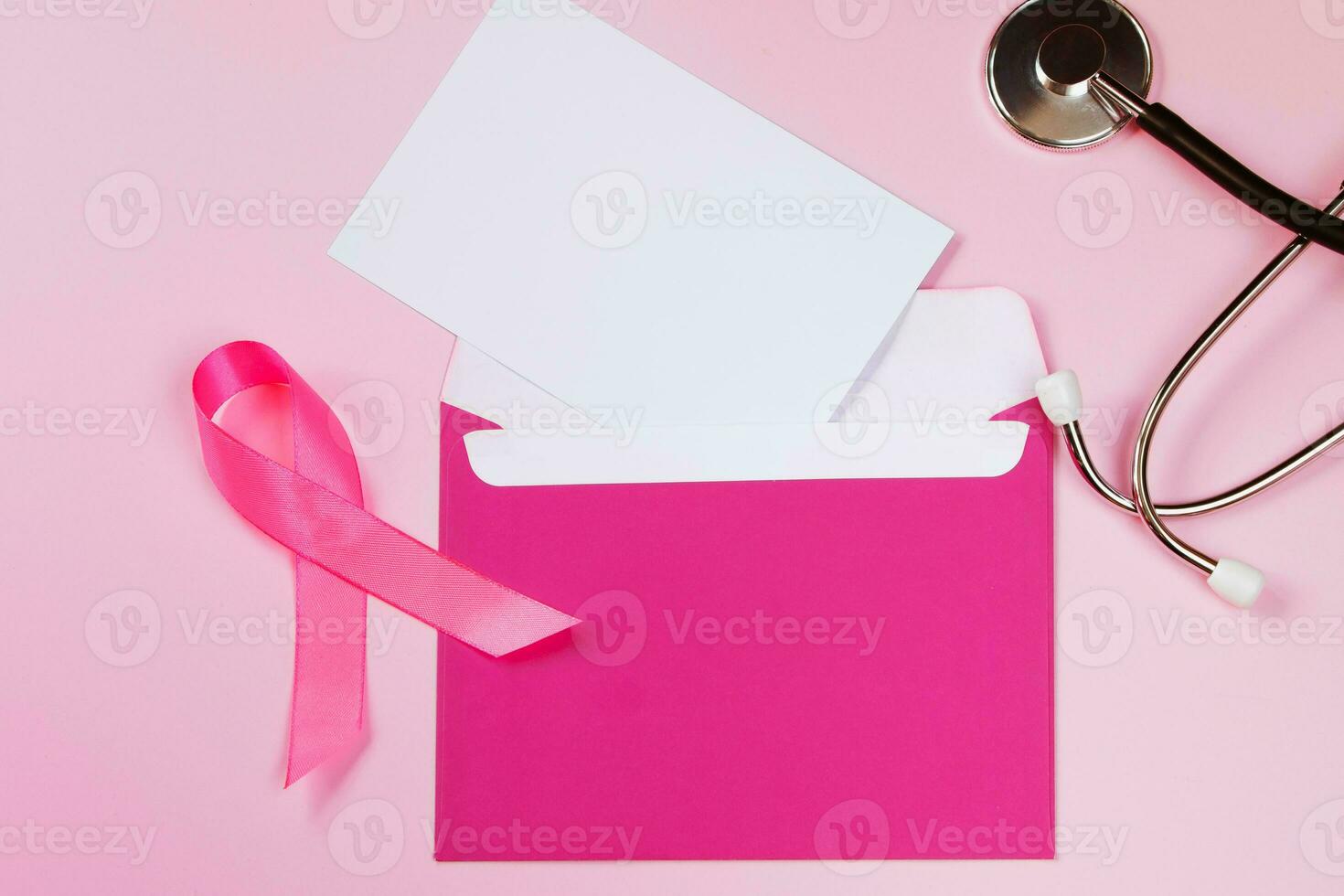 Breast Cancer Awareness Month. Women's health care concept. Pink ribbon and stethoscope on colored background. Envelope mockup. photo