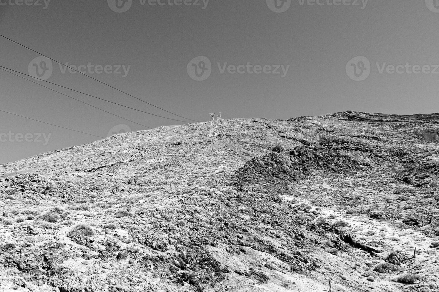 volcánico paisaje con un cable coche a el parte superior de el montaña de el Español teide volcán en tenerife, canario islas foto