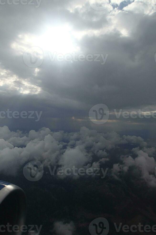 white clouds against the blue sky seen from the flight from the windows of the plane photo