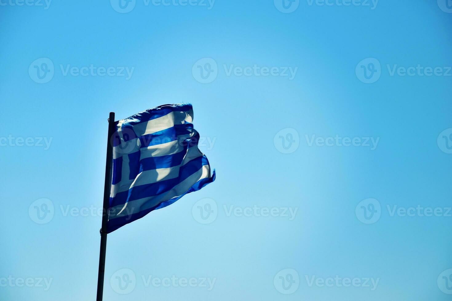 griego bandera en contra un azul cielo en un calentar soleado día foto