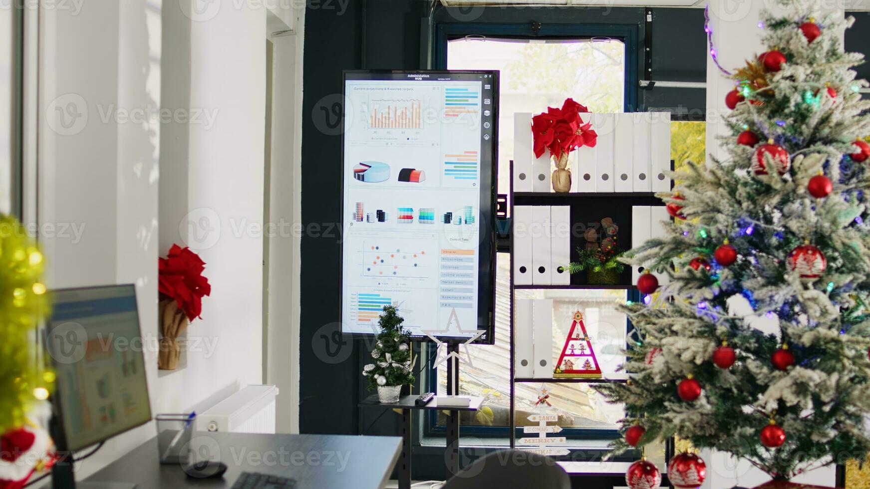 Dolly out shot of empty festive ornate office workspace with beautiful Christmas tree and pine wreaths. Xmas adorn professional workplace ready for festivities before winter holiday season vacation photo