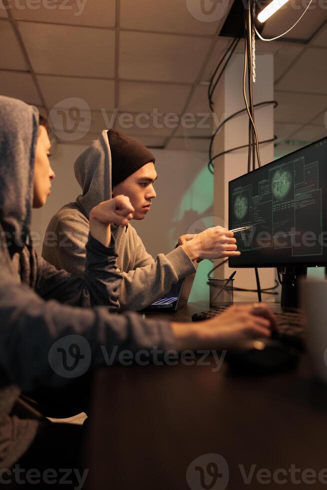 Spies team working on cyberterrorism with virus, planning attack to steal personal information. Two people talking about encryption, criminals breaking into government system at night. photo