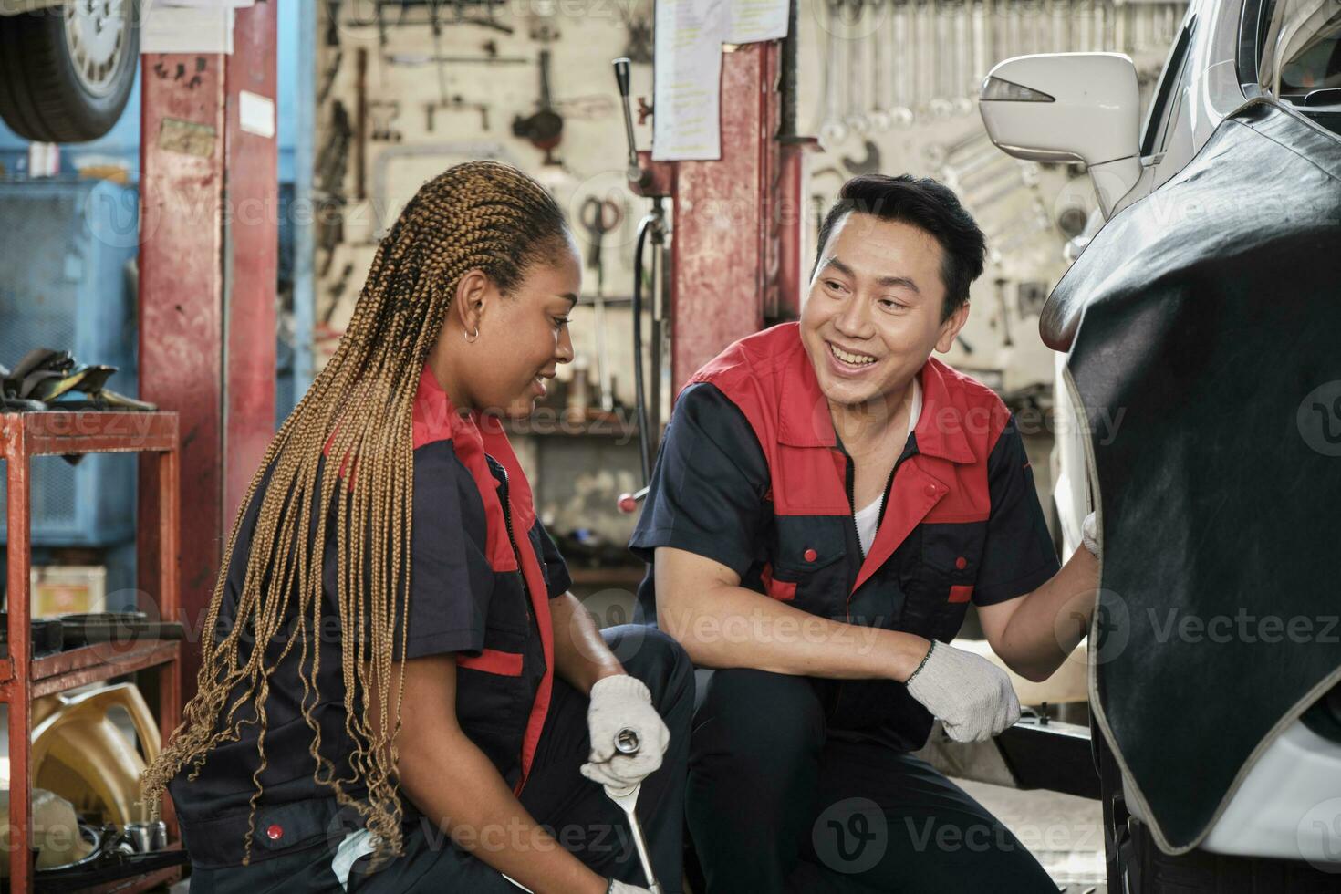 profesional masculino automotor supervisor entrenado negro hembra mecánico técnico a tornillo coche rueda nueces para reparar a cochera, vehículo mantenimiento Servicio trabajos industria ocupación negocio trabajos. foto