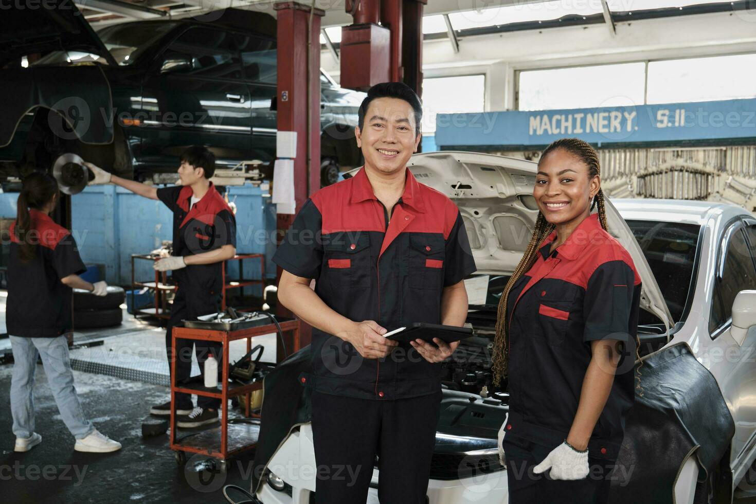 retrato de profesional mecánico supervisor socios Mira a cámara, trabajo a coche Servicio cochera, contento mantenimiento trabajos, cheque y reparar ingeniero ocupación en automotor industria negocio. foto