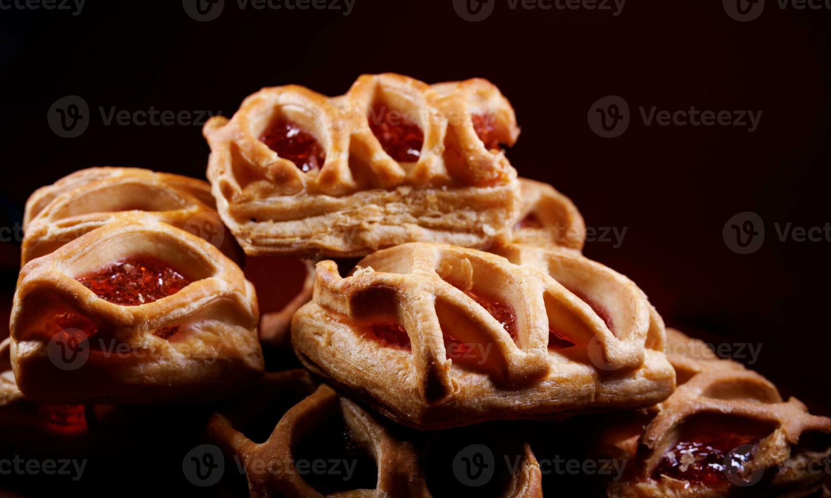 soplo Pastelería Pastelería con arándano rojo mermelada en un oscuro rojo antecedentes. galletas con arándano rojo mermelada. foto