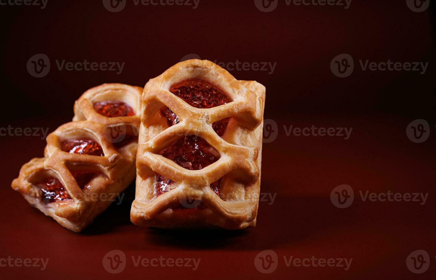 soplo Pastelería Pastelería con arándano rojo mermelada en un oscuro rojo antecedentes. galletas con arándano rojo mermelada. foto