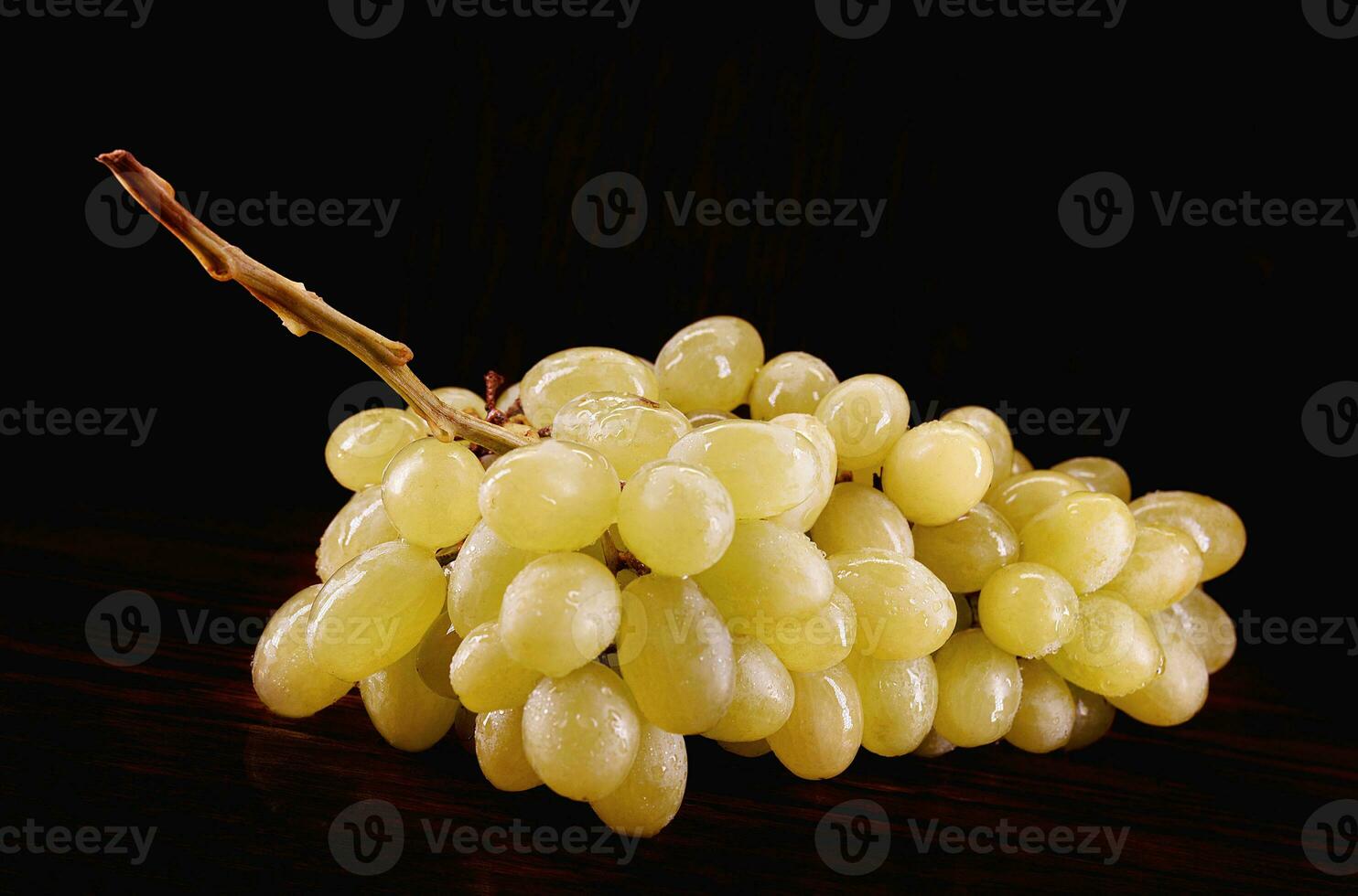 A bunch of green grapes on a dark background. photo