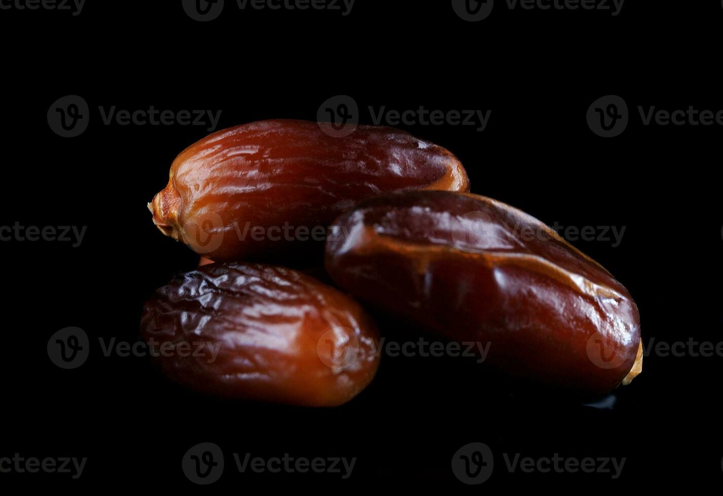 Several ripe dates on a black background. Delicious dates on black. photo