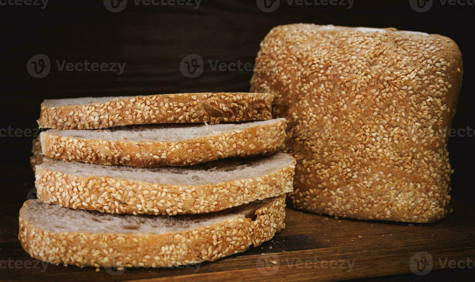 Cut loaf of bread and pieces of bread on a wooden background. Ciabatta bread. photo