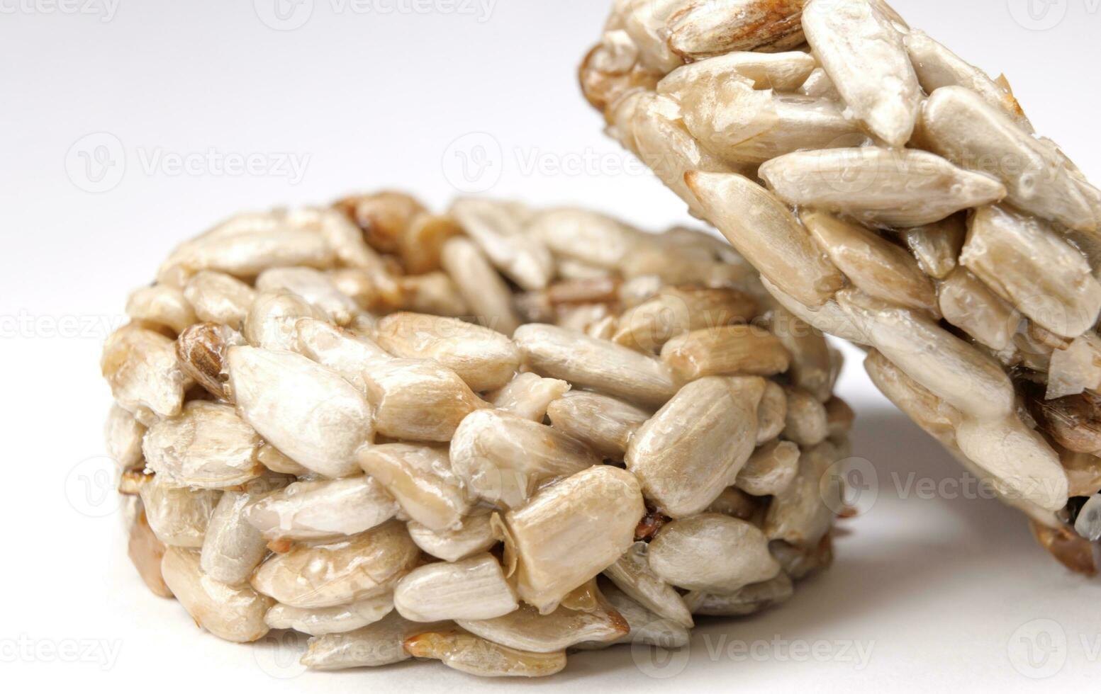 Kozinaki from sunflower seeds on a white background. Round kozinaki. photo