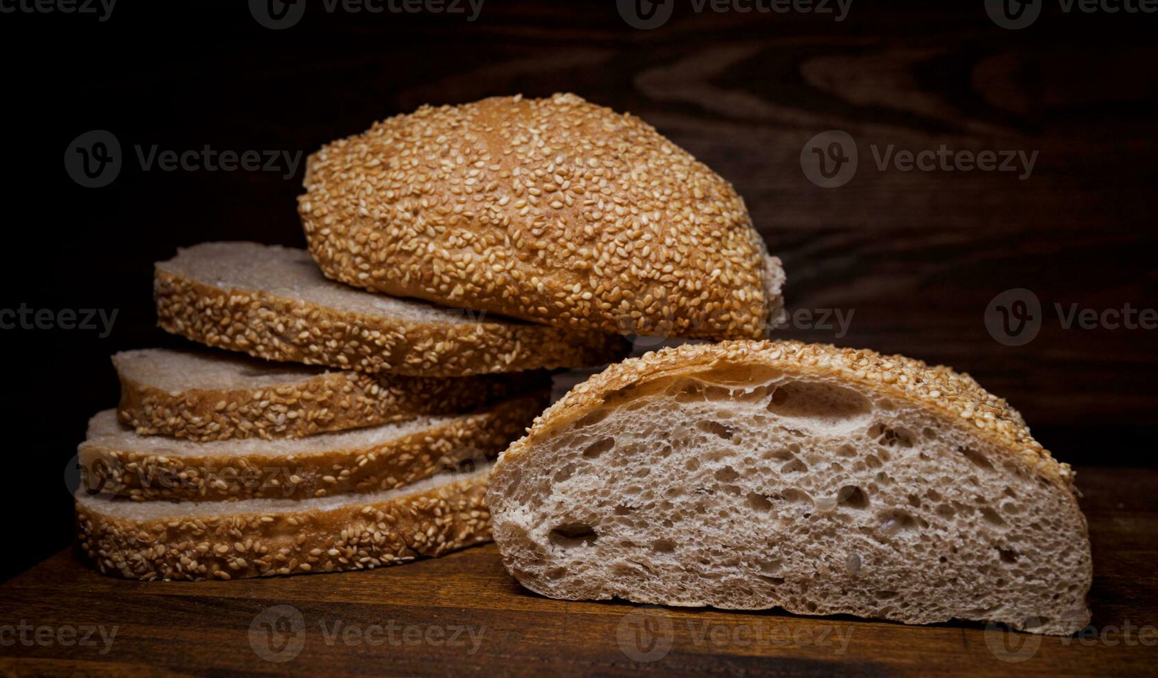 Cut loaf of bread and pieces of bread on a wooden background. Ciabatta bread. photo