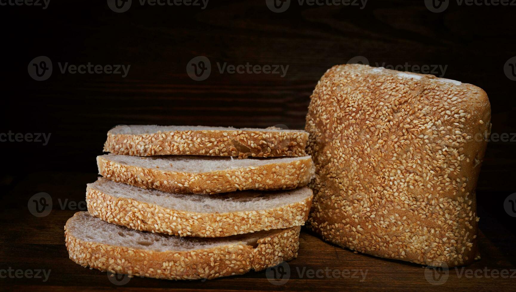 Cut loaf of bread and pieces of bread on a wooden background. Ciabatta bread. photo