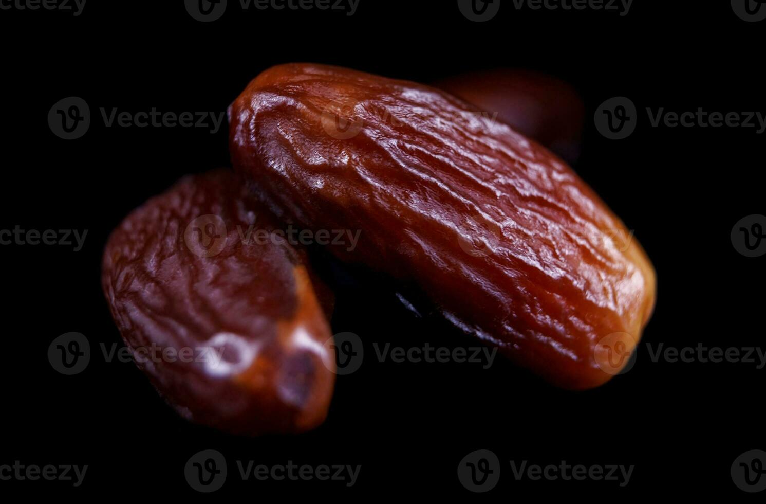 Several ripe dates on a black background. Delicious dates on black. photo