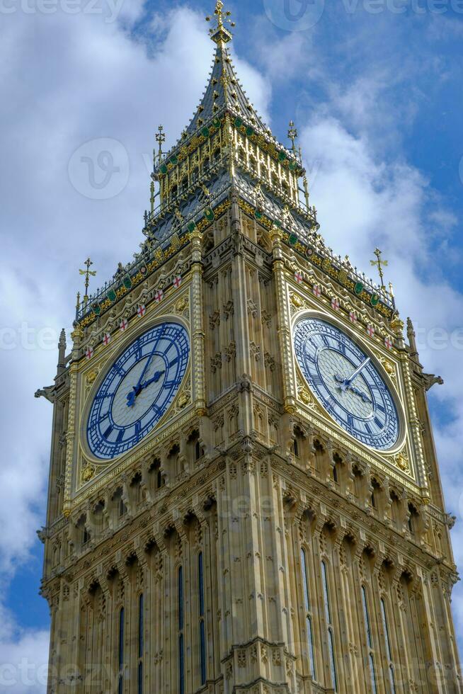 Big Ben clock set against partially cloudy blue sky. London Landmark. photo
