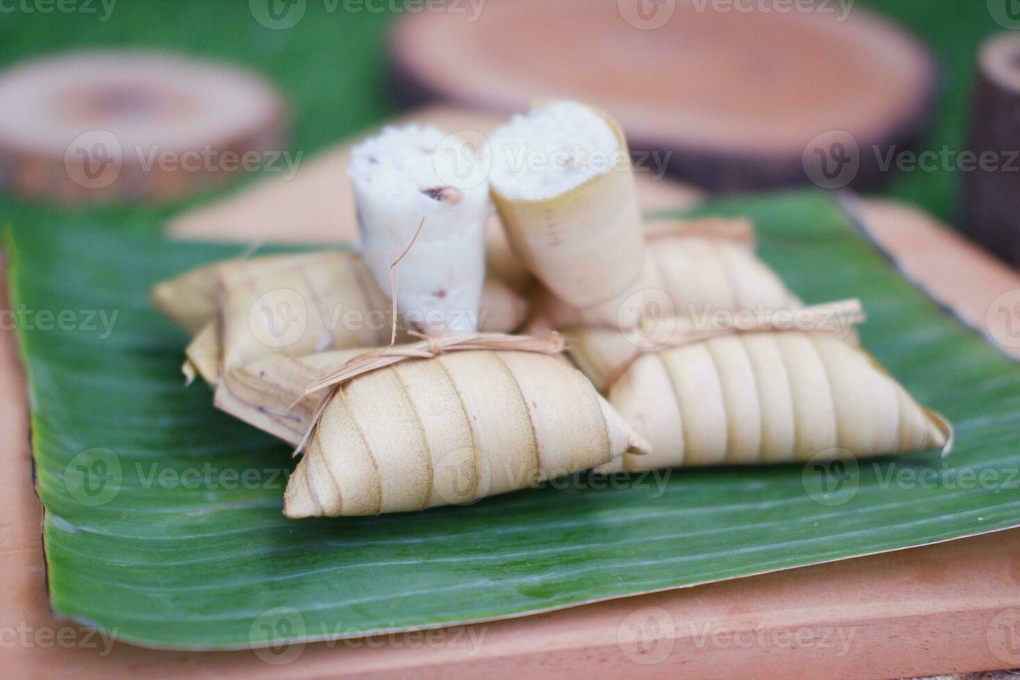Lepet or Leupeut is a type of snack made from glutinous rice mixed with peanuts, cooked in coconut milk, then wrapped in coconut leaves. Close up view photo