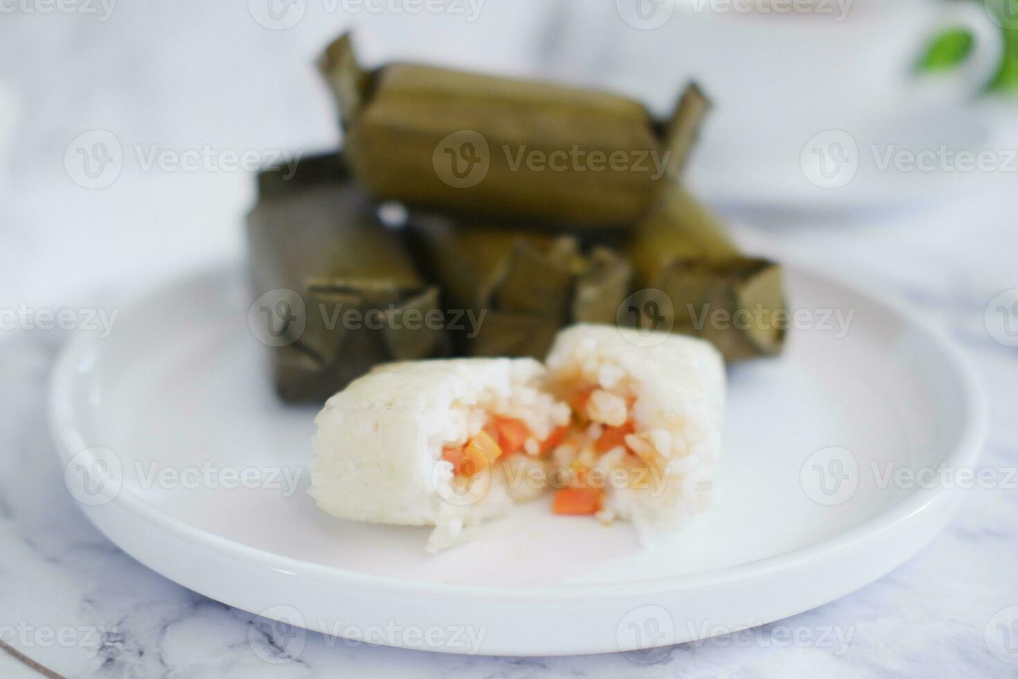 Arem-arem, a traditional food made from rice filled with vegetables, chicken, meat or tempeh wrapped in banana leaves. Arem-arem is popular as a breakfast substitute photo