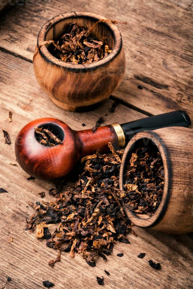 Smoking pipe on wooden table photo